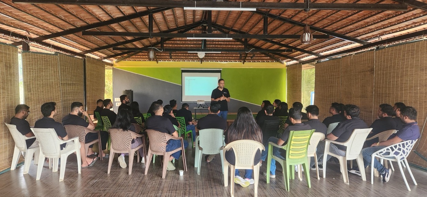 A working session at the offsite, the team seated in an open hall watching a presentation